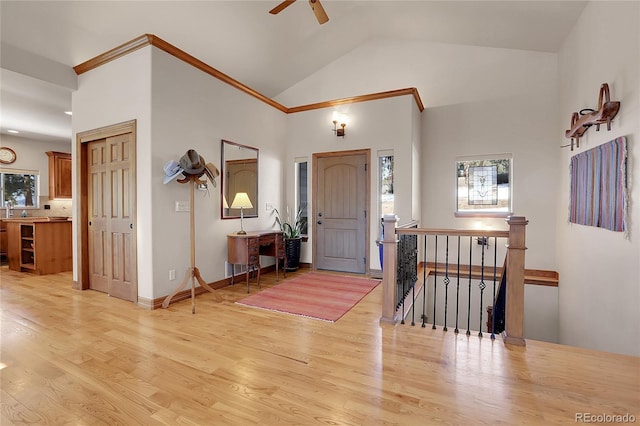 foyer entrance with ceiling fan, light hardwood / wood-style floors, and high vaulted ceiling