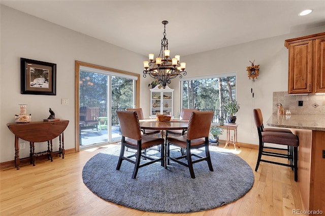 dining area with light hardwood / wood-style flooring and a chandelier