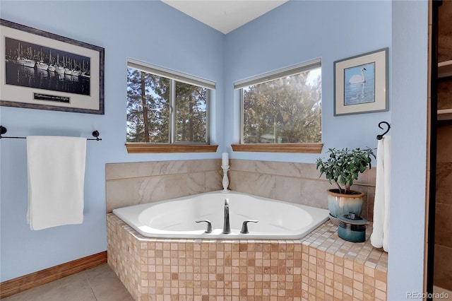 bathroom with tiled tub and tile patterned flooring