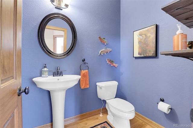 bathroom with hardwood / wood-style floors and toilet