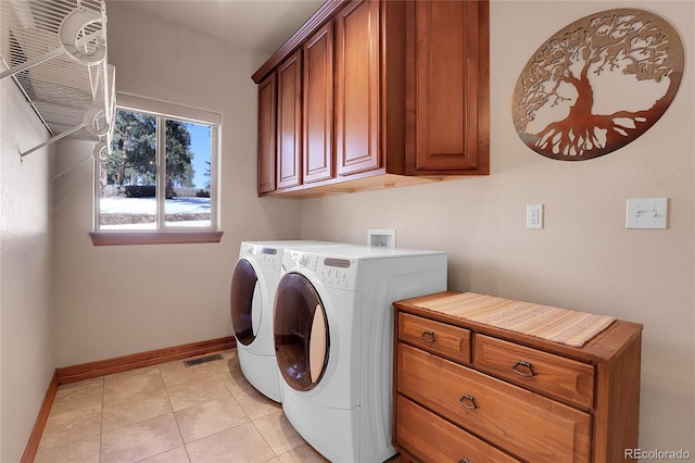 laundry area featuring cabinets, washing machine and clothes dryer, and light tile patterned flooring