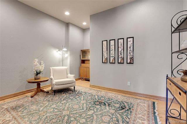 living area with hardwood / wood-style flooring and a high ceiling