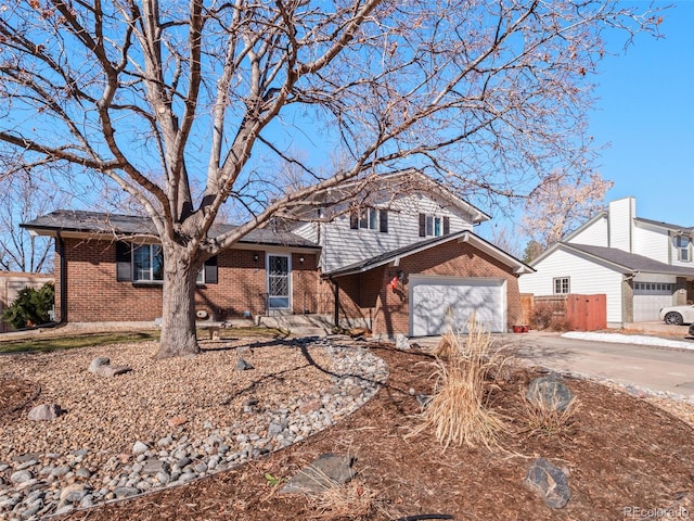 split level home featuring driveway, a garage, and brick siding