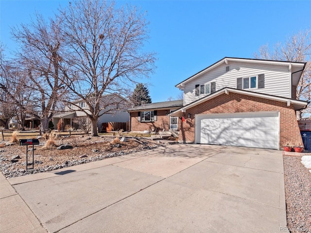 split level home featuring a garage, concrete driveway, and brick siding