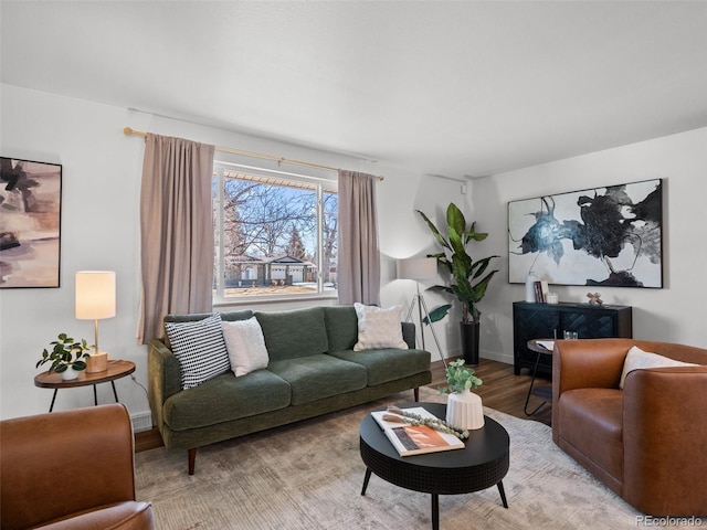 living area featuring baseboards and light wood finished floors