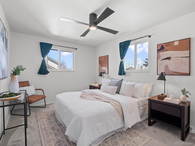 bedroom featuring light carpet, multiple windows, and a ceiling fan