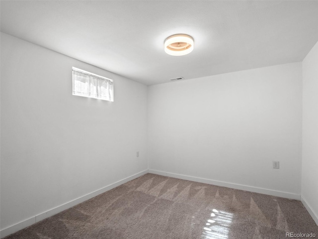 empty room featuring carpet, visible vents, and baseboards