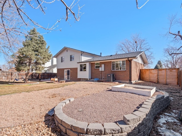 back of house featuring brick siding, a patio, a fenced backyard, and central AC unit