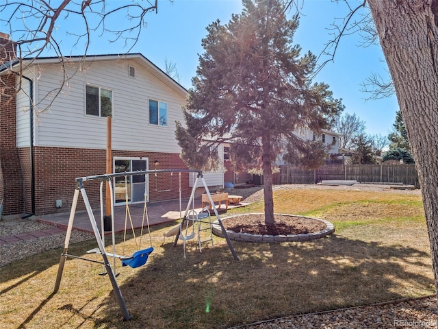 rear view of property with a patio, brick siding, fence, a lawn, and a chimney