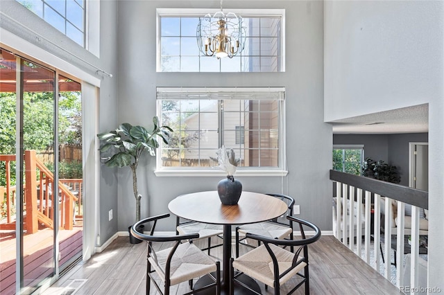 19937 E Loyola Pl, Aurora, CO 80013 - dining space with wood finished floors, a chandelier, and a towering ceiling