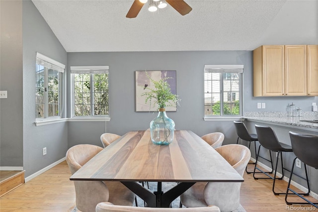 19937 E Loyola Pl, Aurora, CO 80013 - dining space with vaulted ceiling, plenty of natural light, light wood-type flooring, a ceiling fan, and a textured ceiling