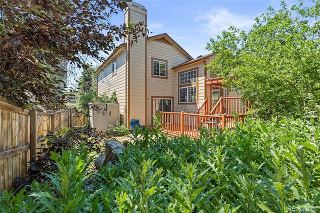 19937 E Loyola Pl, Aurora, CO 80013 - back of property featuring a deck, a fenced backyard, a chimney, and a shed