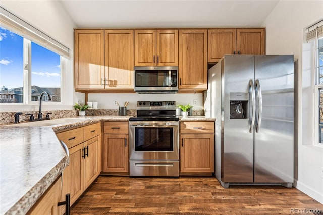 kitchen featuring dark wood-style floors, light countertops, appliances with stainless steel finishes, and a sink