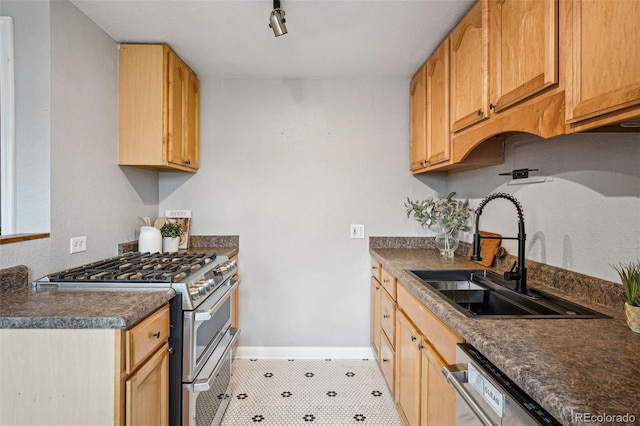 kitchen with baseboards, dark countertops, a sink, and double oven range