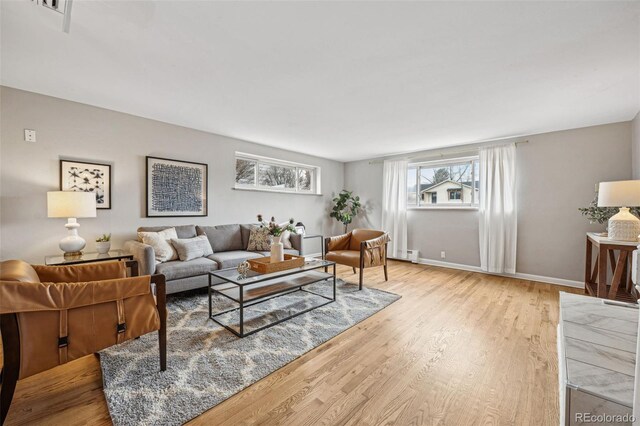 living area featuring light wood finished floors and baseboards