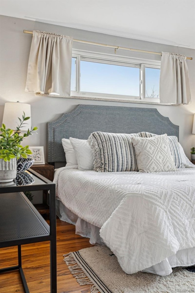 bedroom featuring multiple windows and wood finished floors