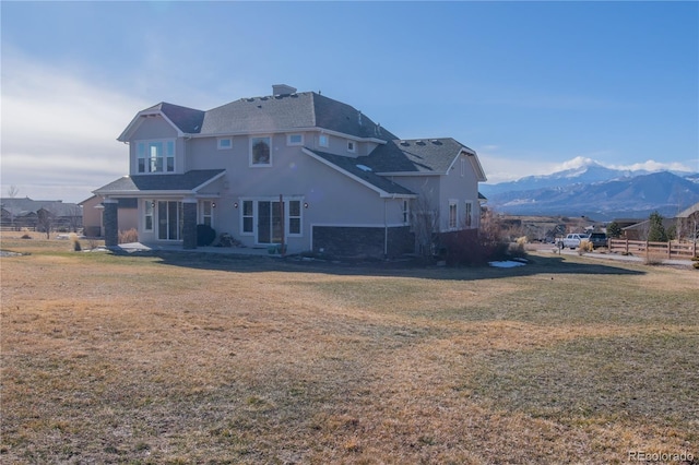 rear view of property with a mountain view and a yard