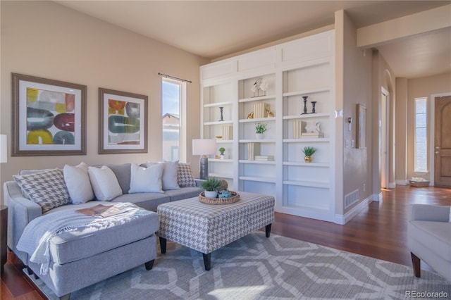 living area with built in features and dark wood-type flooring