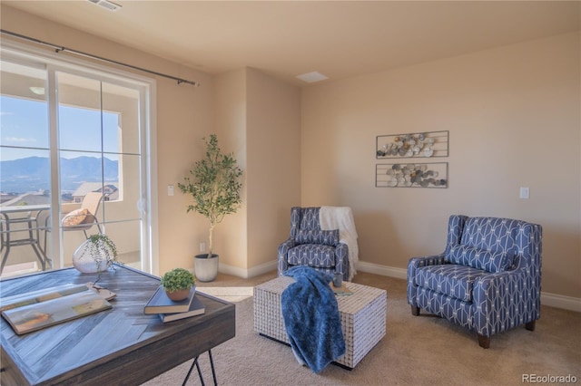 sitting room featuring a mountain view and carpet floors