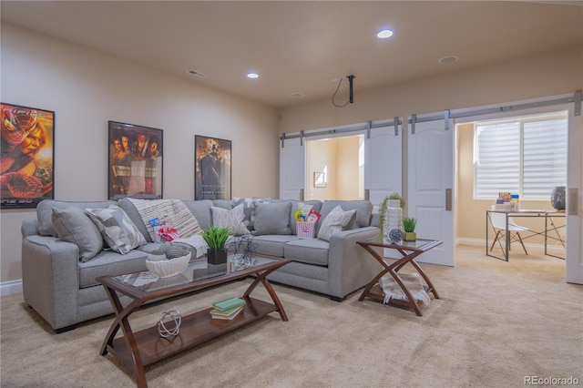 living room featuring light carpet and a barn door