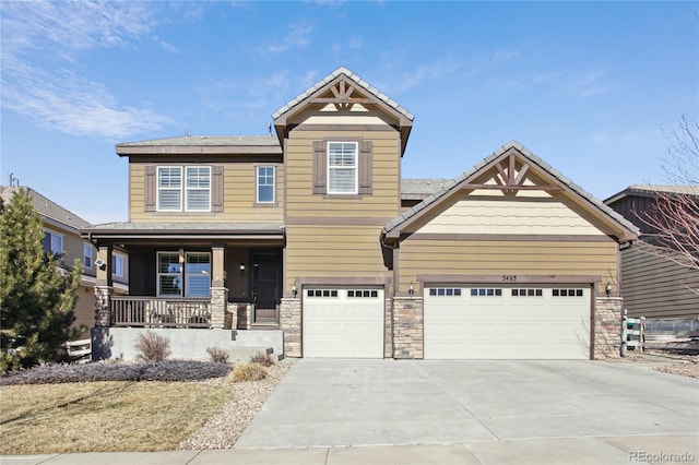 craftsman-style home with a garage, concrete driveway, a porch, and stone siding