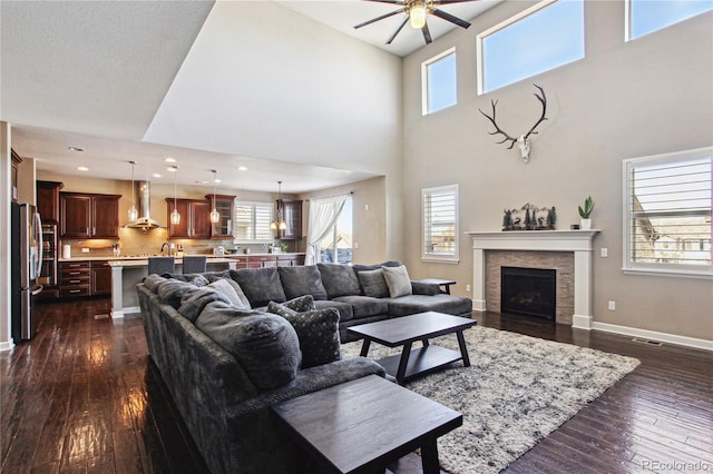 living room featuring dark wood-style floors, a wealth of natural light, and baseboards