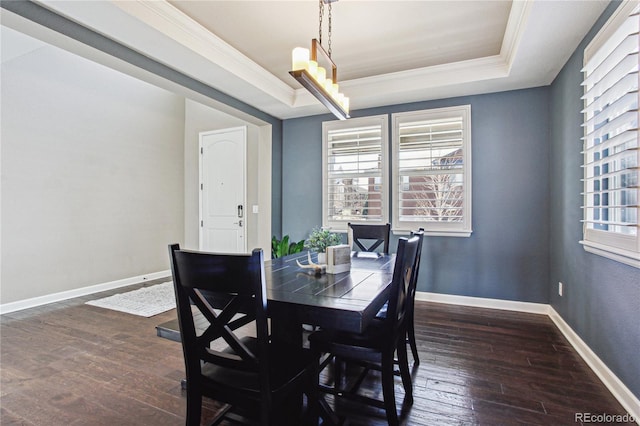 dining space featuring baseboards, a raised ceiling, dark wood-type flooring, and ornamental molding