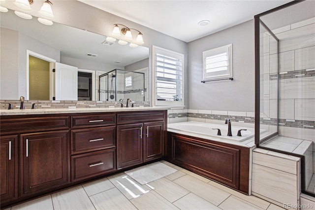 bathroom featuring double vanity, a sink, a bath, and a shower stall