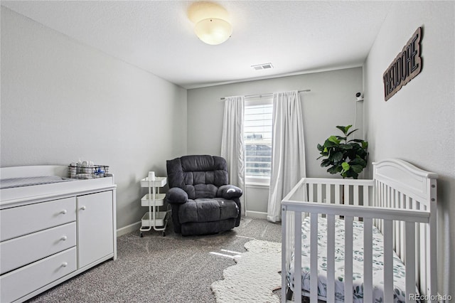 bedroom with light carpet, baseboards, visible vents, a textured ceiling, and a nursery area