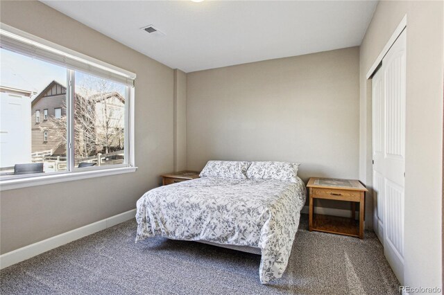 carpeted bedroom with baseboards and a closet