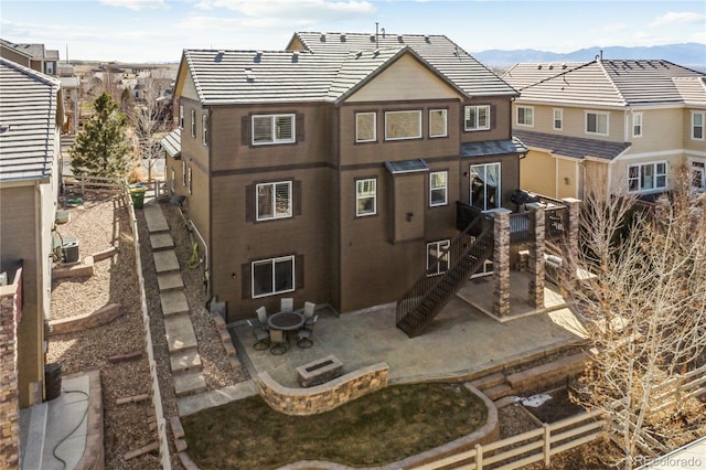 back of house with a patio, a residential view, fence, and a tiled roof