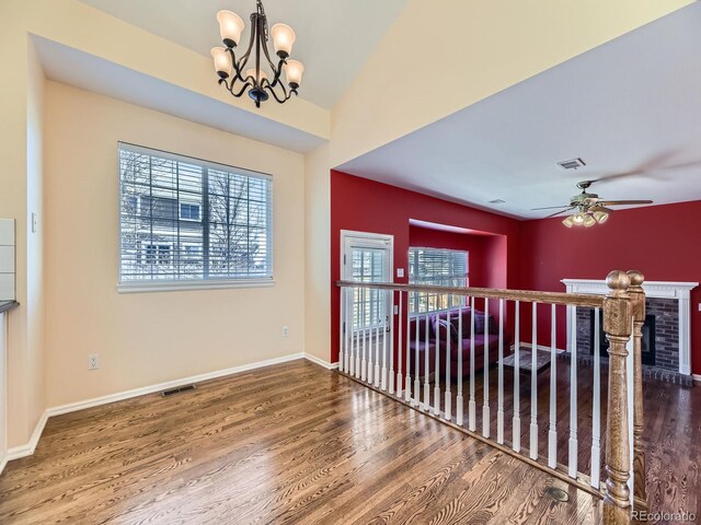 unfurnished room featuring visible vents, plenty of natural light, baseboards, and wood finished floors