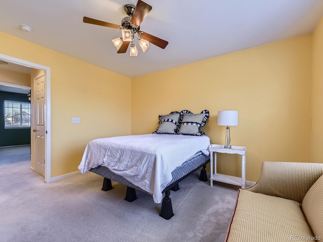 carpeted bedroom with ceiling fan and baseboards