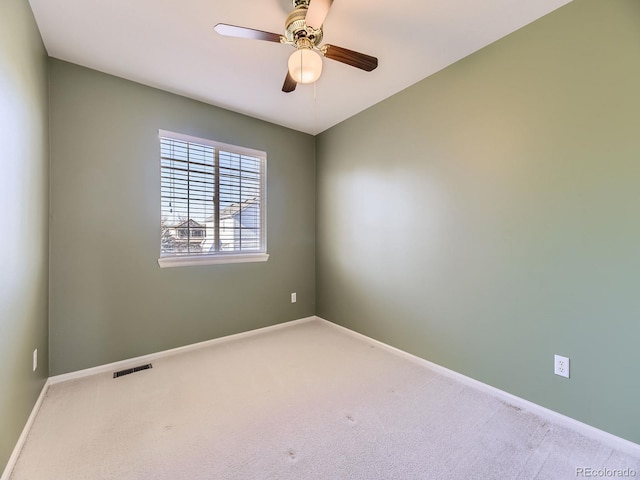 carpeted empty room with visible vents, ceiling fan, and baseboards