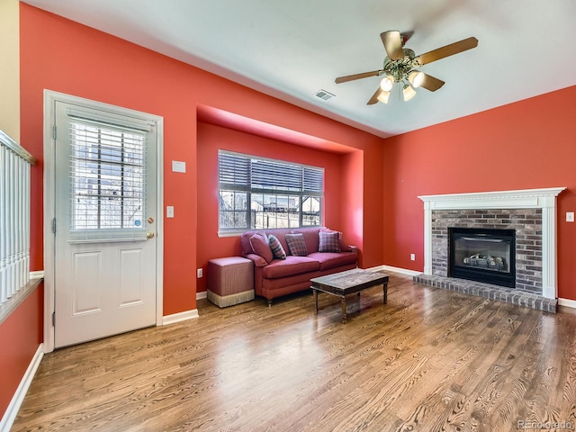 living room featuring a wealth of natural light, visible vents, and wood finished floors