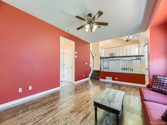 living room featuring visible vents, baseboards, and wood finished floors