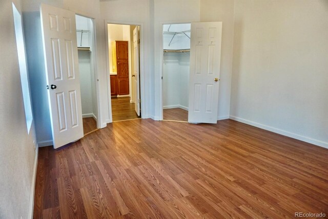 unfurnished bedroom with dark hardwood / wood-style flooring, a spacious closet, and a closet