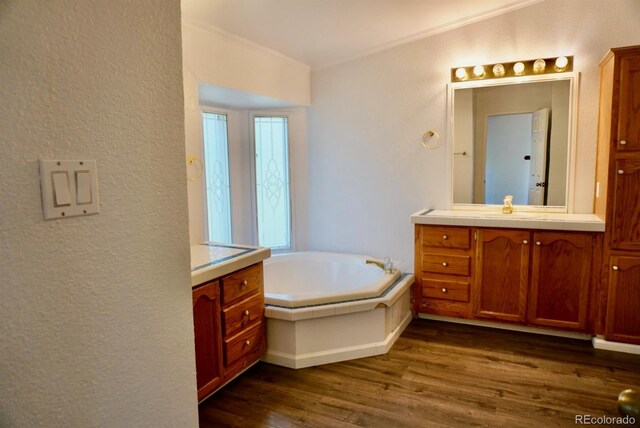 bathroom featuring crown molding, vanity, a bath, and hardwood / wood-style flooring