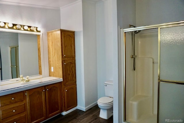 bathroom featuring crown molding, walk in shower, toilet, wood-type flooring, and vanity