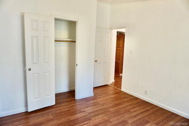 unfurnished bedroom featuring a closet and hardwood / wood-style flooring