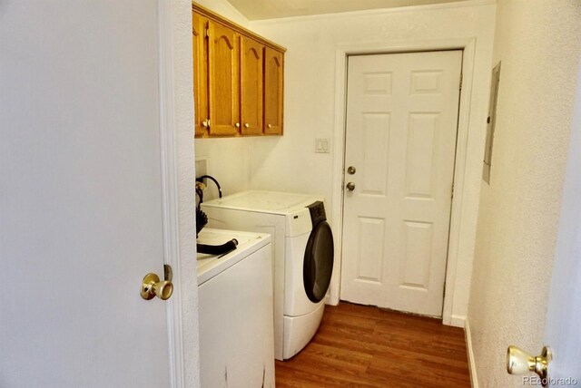 clothes washing area featuring dark hardwood / wood-style flooring, cabinets, and washer and dryer