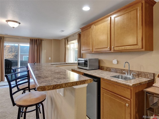 kitchen with a center island, stainless steel appliances, a breakfast bar, and sink