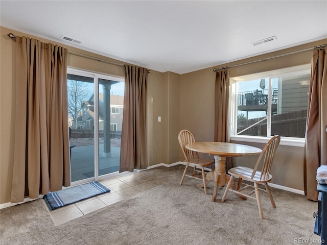 carpeted dining space with a healthy amount of sunlight