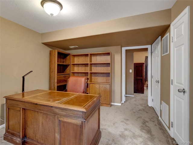 unfurnished office with light carpet and a textured ceiling