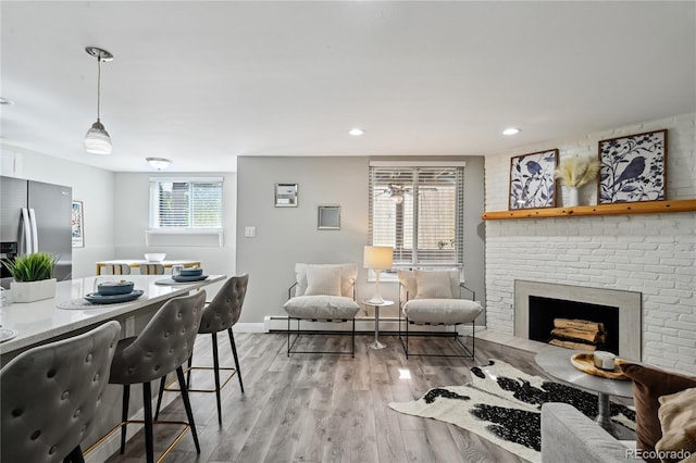1390 Everett Ct Unit 105, Lakewood, CO 80215 - living room with light wood finished floors, a baseboard heating unit, a fireplace, baseboards, and recessed lighting