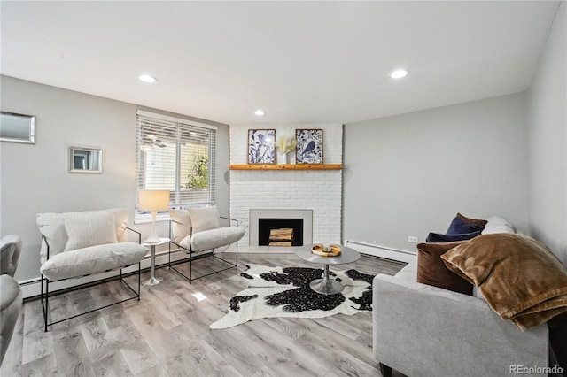 1390 Everett Ct Unit 105, Lakewood, CO 80215 - living area with a baseboard heating unit, wood finished floors, a fireplace, and recessed lighting