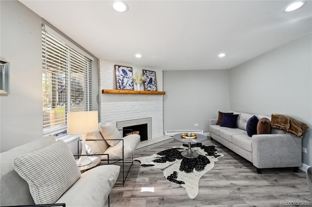 1390 Everett Ct Unit 105, Lakewood, CO 80215 - living room with recessed lighting, a brick fireplace, wood finished floors, baseboards, and a baseboard radiator