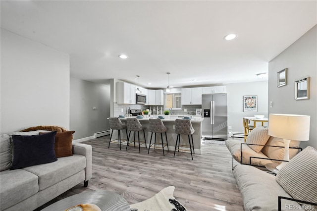 1390 Everett Ct Unit 105, Lakewood, CO 80215 - living room featuring a baseboard heating unit, recessed lighting, light wood-type flooring, baseboards, and a baseboard radiator