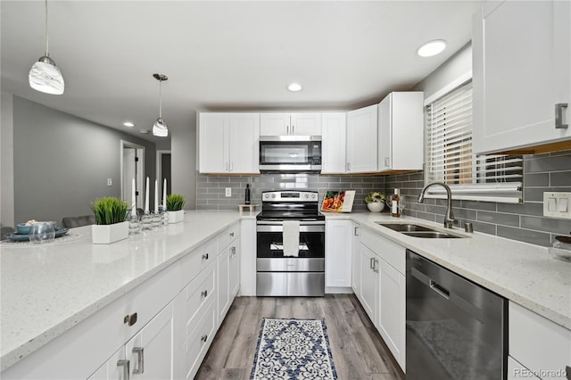 1390 Everett Ct Unit 105, Lakewood, CO 80215 - kitchen with stainless steel appliances, a sink, white cabinets, backsplash, and recessed lighting