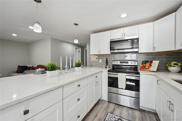 1390 Everett Ct Unit 105, Lakewood, CO 80215 - kitchen with appliances with stainless steel finishes, white cabinetry, tasteful backsplash, pendant lighting, and light wood-style flooring